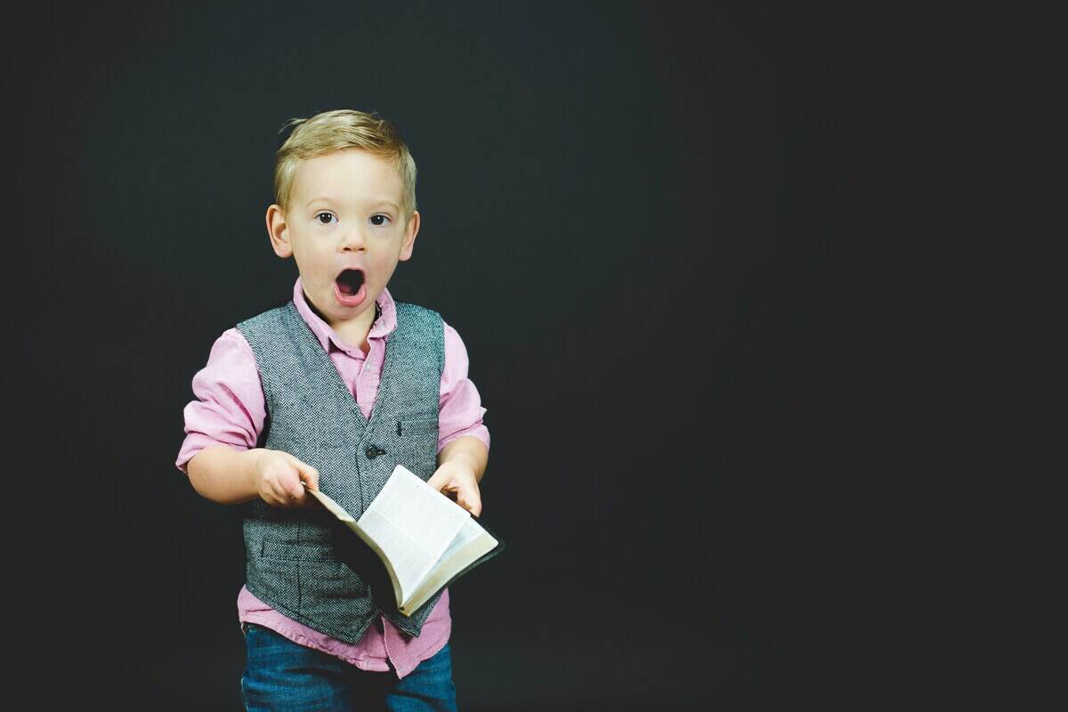 bambino con libro ed espressione stupita